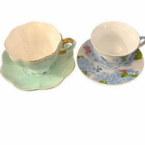 Coordinating set of two tea cups with saucer matching saucers.